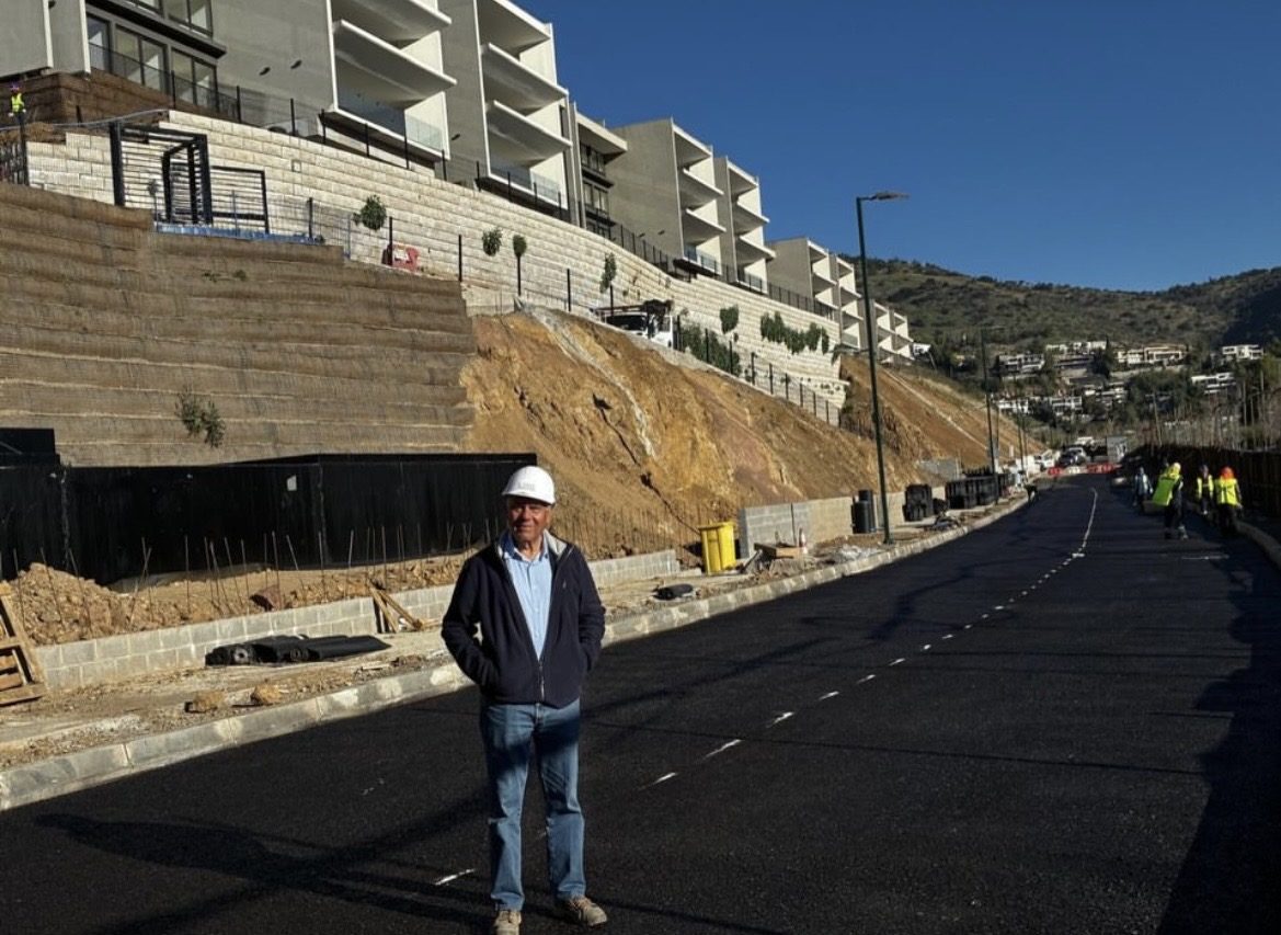 Calzada asfáltica terminada junto a un muro de contención